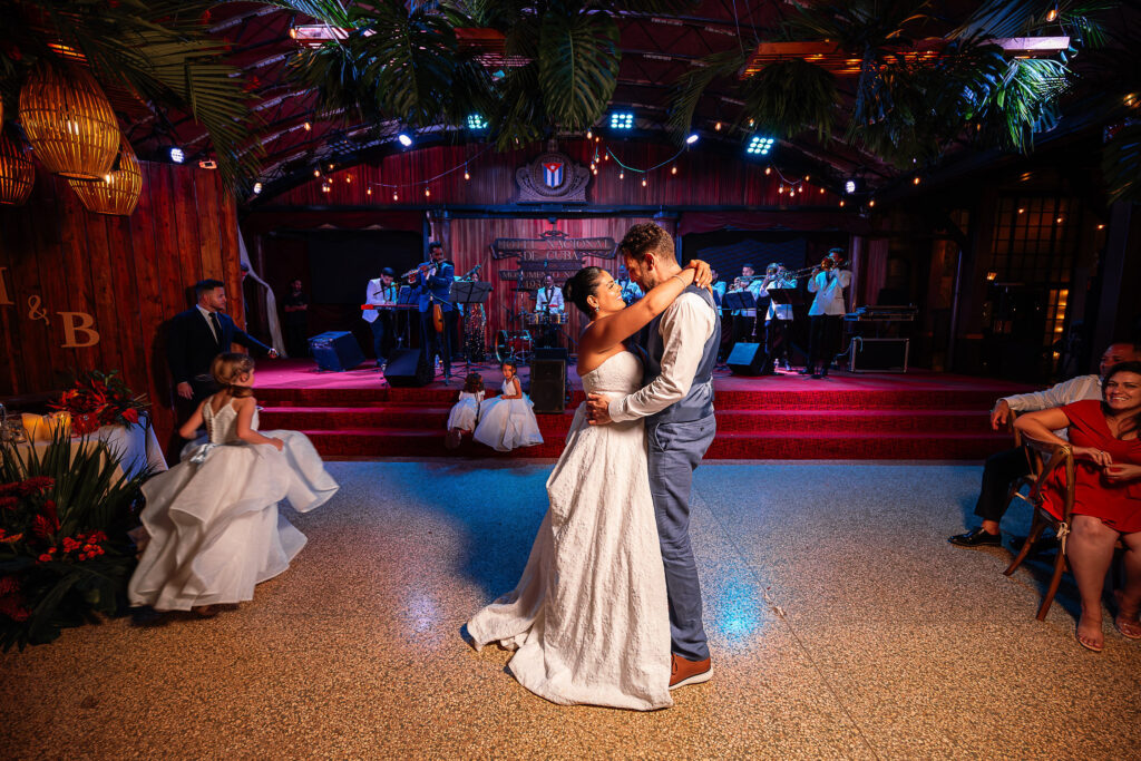 Couple dancing in the Hotel Nacional ballroom with tropical flowers and warm lighting