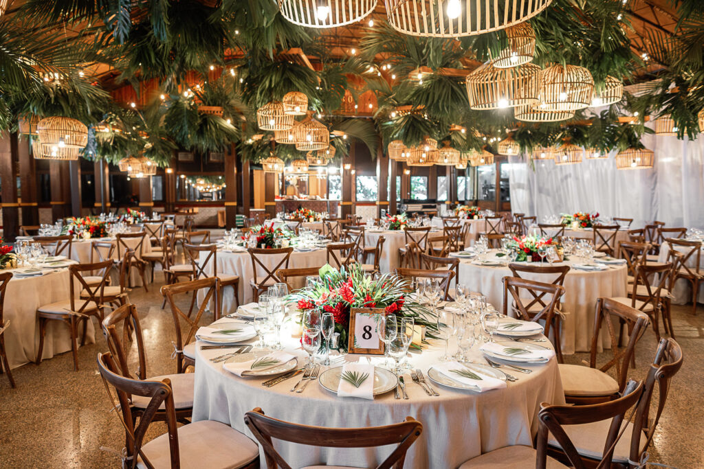 Tables decorated with warm lighting, tropical flowers and wooden elements at a wedding in the Hotel Nacional