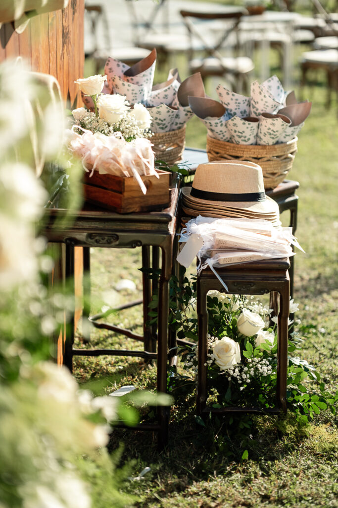 Sombreros y abanicos blancos como recuerdos de boda sobre mesas decoradas