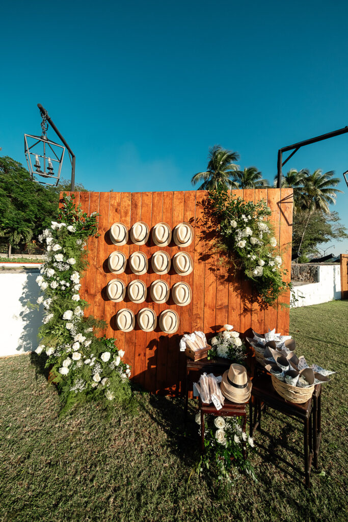 Pared de madera decorada con flores blancas y recuerdos para los invitados