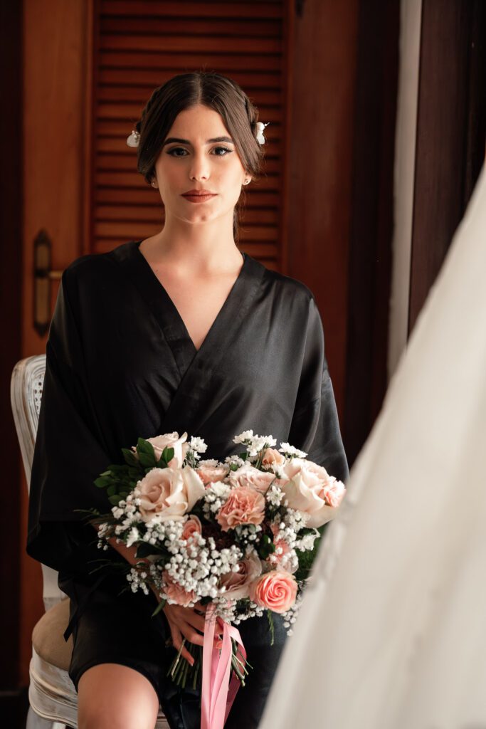 Bride in a black robe holding her bouquet before the ceremony in Havana