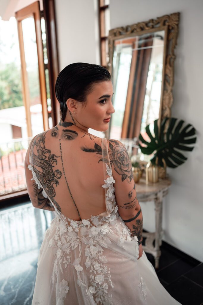 Tattoos and floral lace on the back of one of the brides' dresses