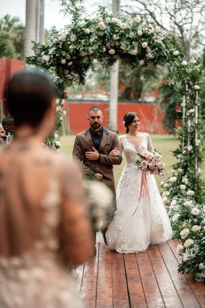 Gabriela walks to the altar on her brother’s arm at her wedding in Cuba under the most beautiful dome