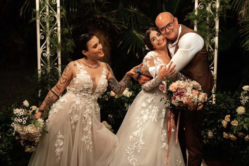 The two brides hugging a relative during their ceremony in Havana
