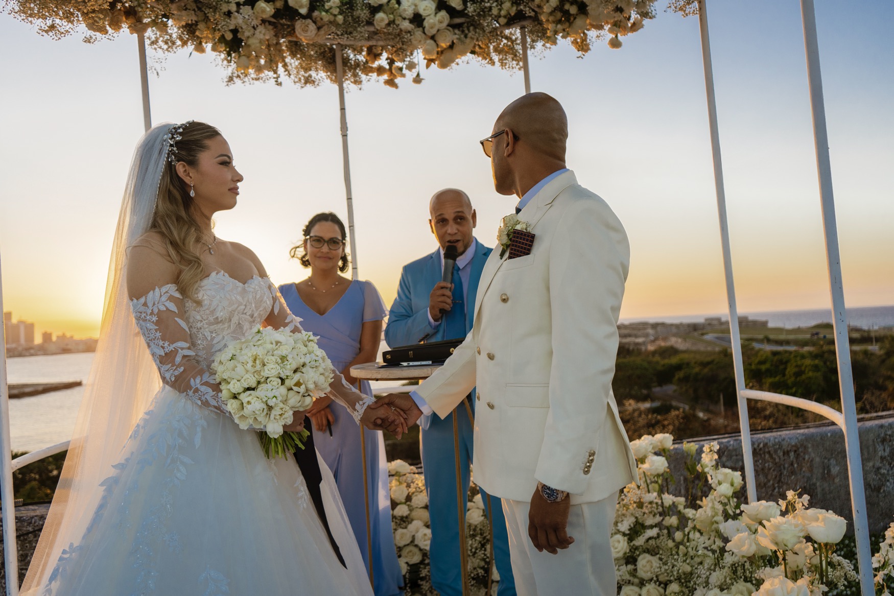 The couple with the notary and the pastor during their civil wedding in Cuba, at the altar of El Morro.
