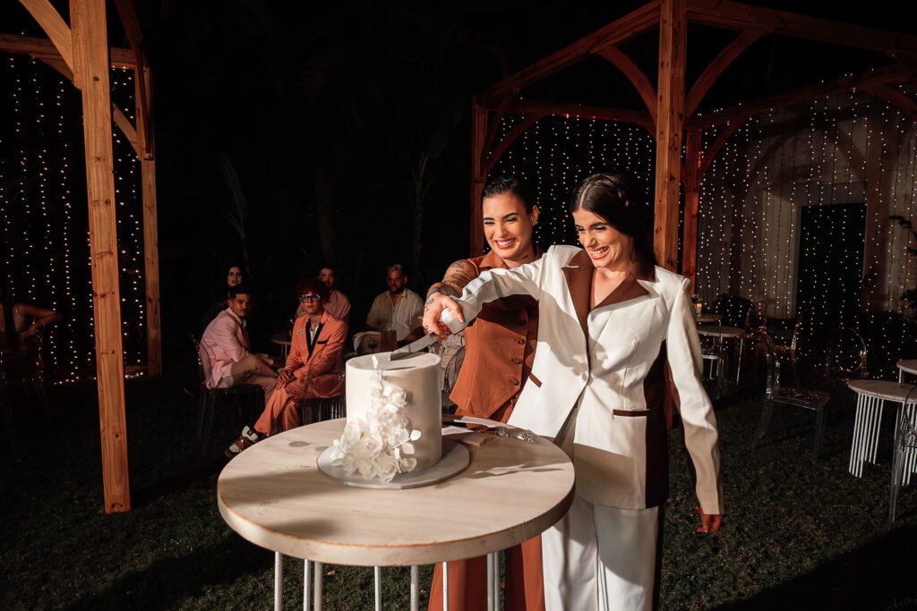 The brides cut the cake together during their wedding in Cuba under the most beautiful dome, surrounded by guests