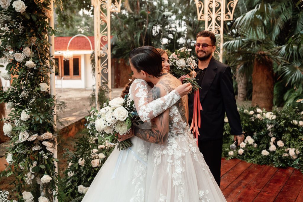 Brides share an emotional hug before starting their ceremony in Cuba under the dome