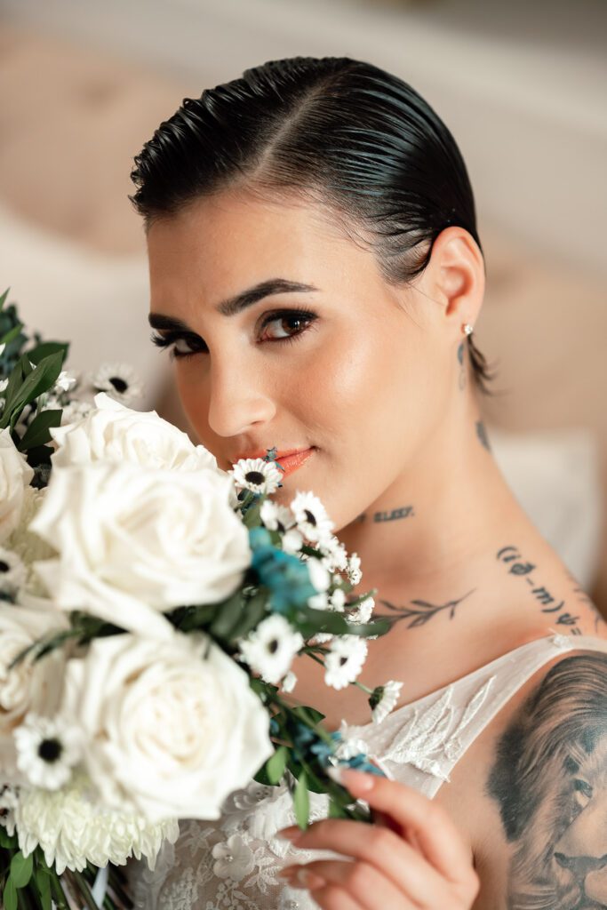Close-up of tattooed bride with white flower bouquet at her ceremony in Havana
