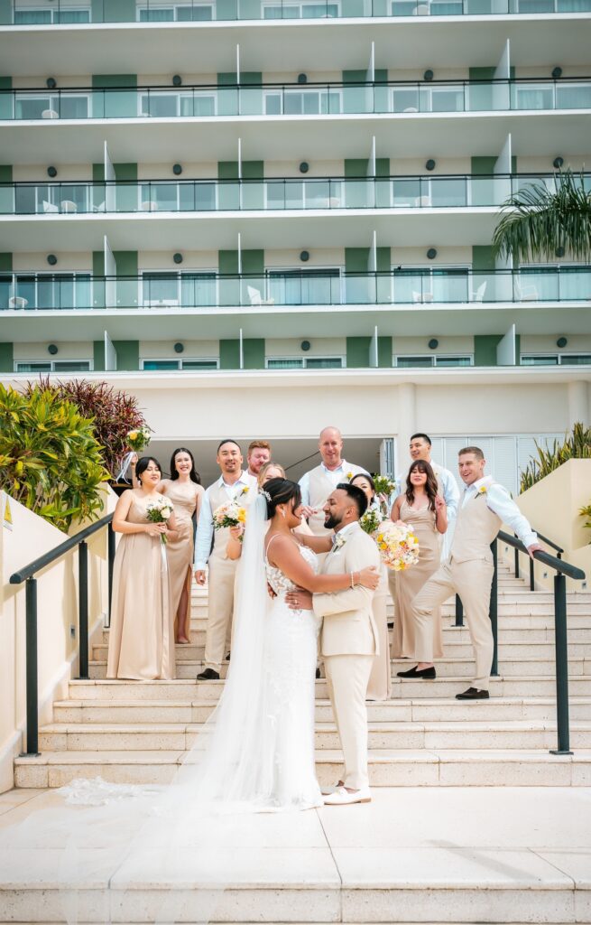 Full wedding party with the couple in front, posing on the steps of the Meliá Internacional Varadero hotel.