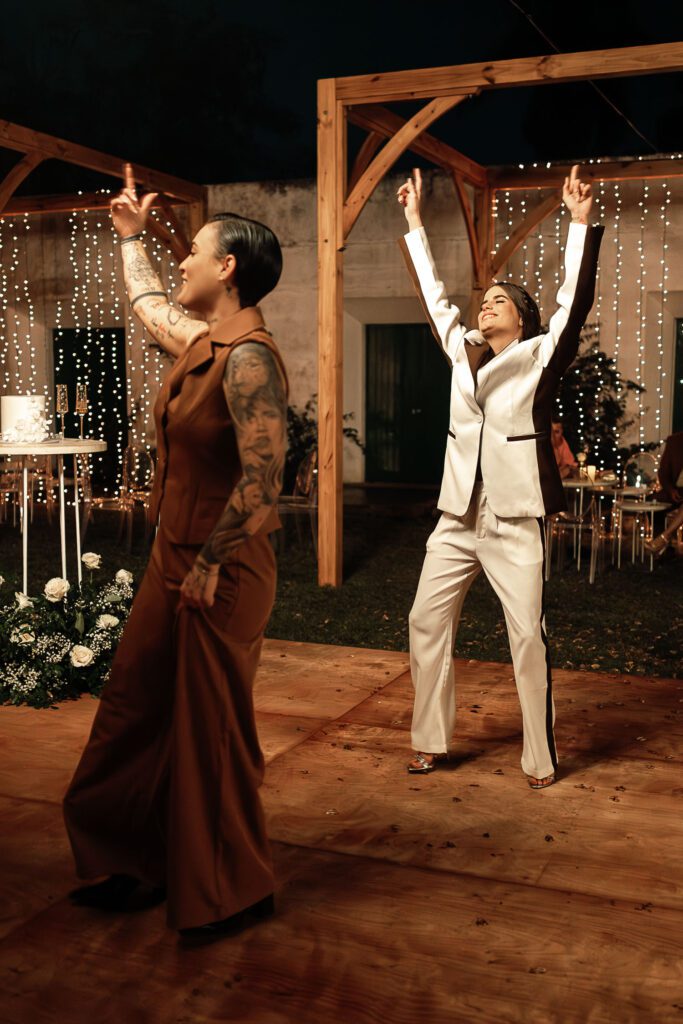 The brides dance with their arms raised during their wedding in Cuba under the most beautiful dome