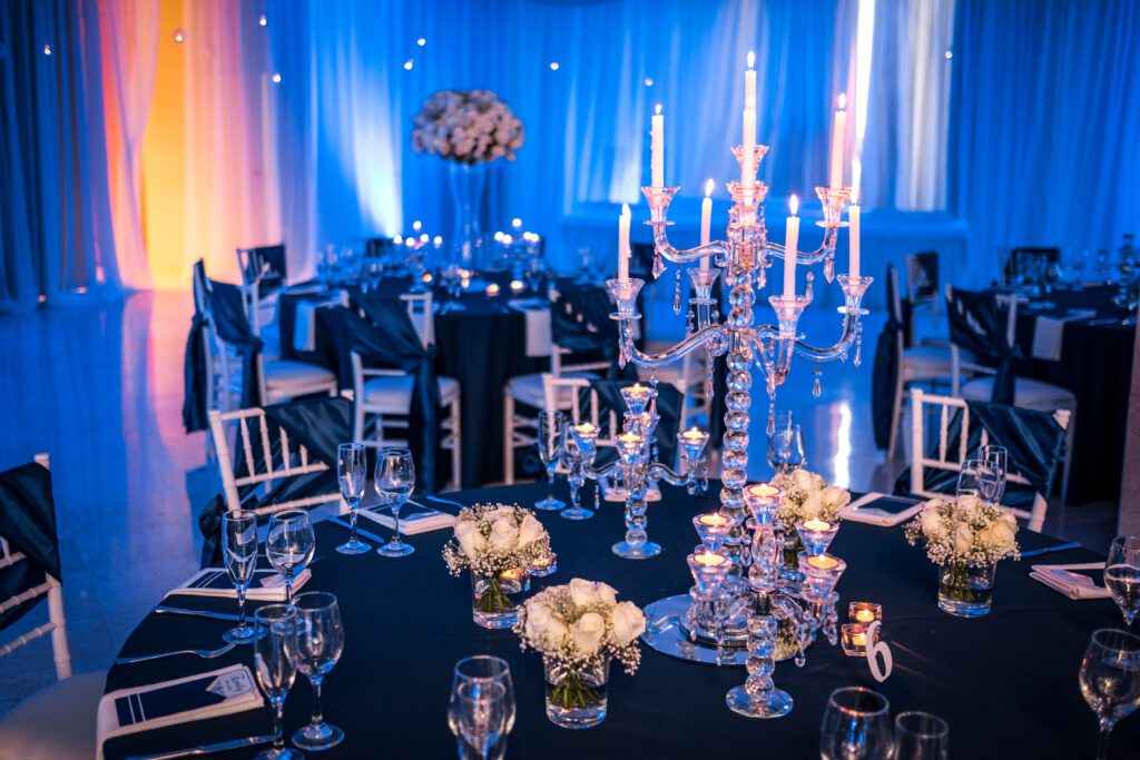 mesas vestidas en azul navy con copas y flores blancas en fiesta de quinceañera en La Habana