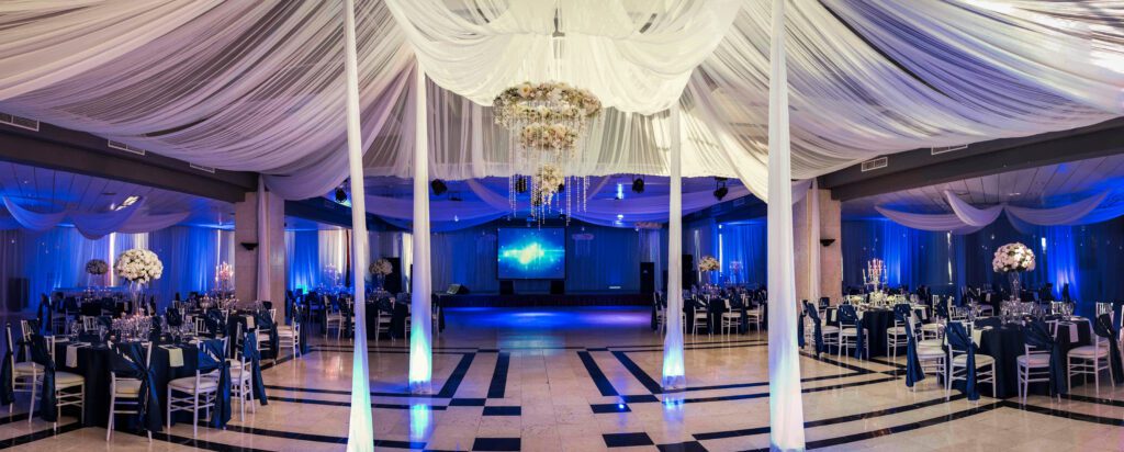 iluminación cálida sobre mesas decoradas en salón para fiesta de quinceañera